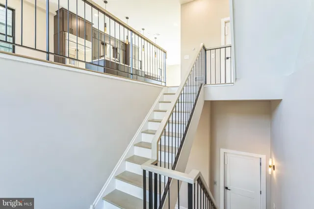 a view of staircase with railing and white walls