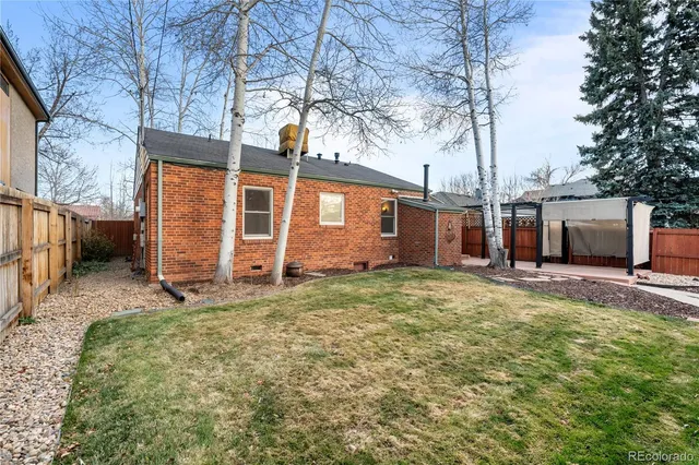 a backyard of a house with oven and a table and chairs