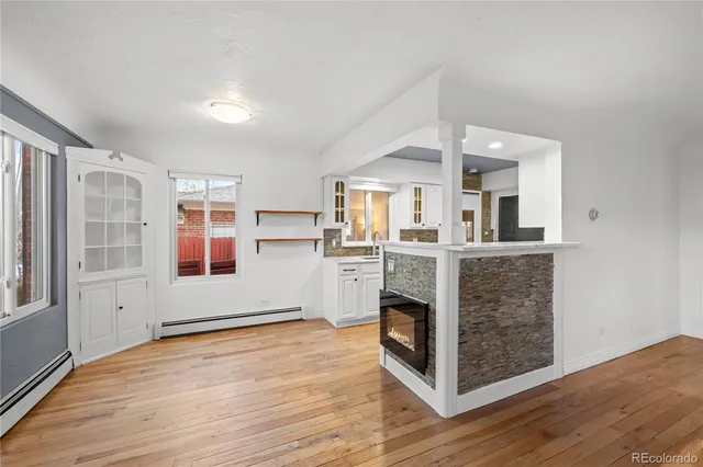 a view of kitchen with stainless steel appliances granite countertop a stove and a wooden floors