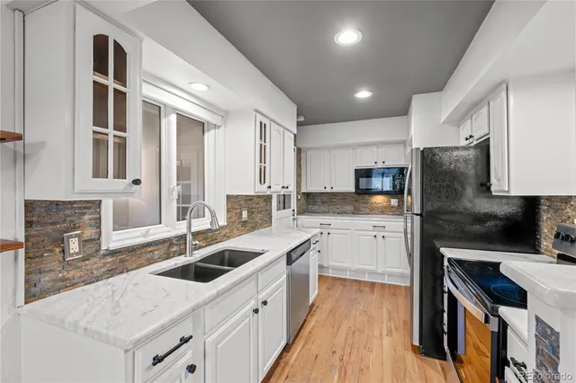 a kitchen with a sink stove top oven and refrigerator