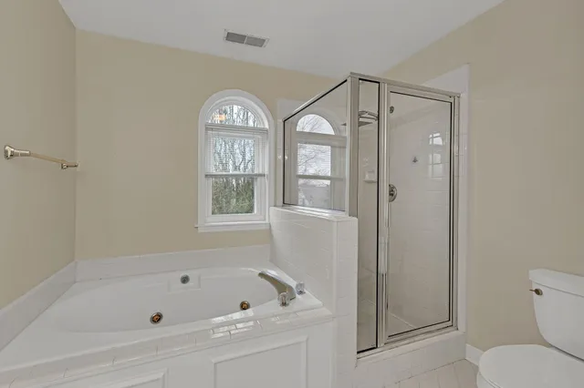 a bathroom with a bathtub shower sink vanity and toilet