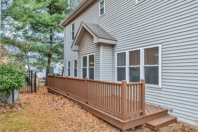 a backyard of a house with wooden fence and large trees