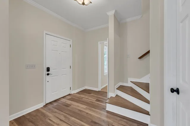 a view of a hallway with wooden floor and staircase