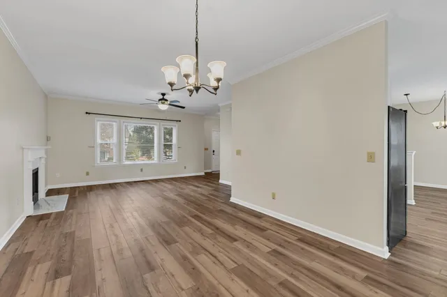 a view of a room with wooden floors and chandelier