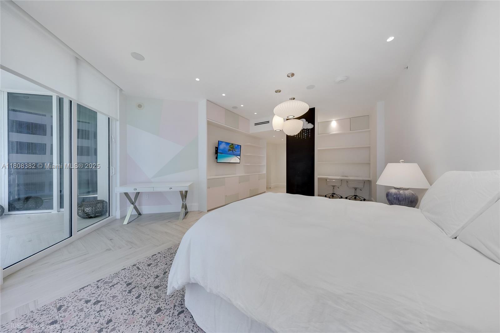 10225 Collins Avenue, Unit 604 Bal Harbour, FL 33154 - Photo 13 of 37 a spacious bedroom with a bed and a chandelier