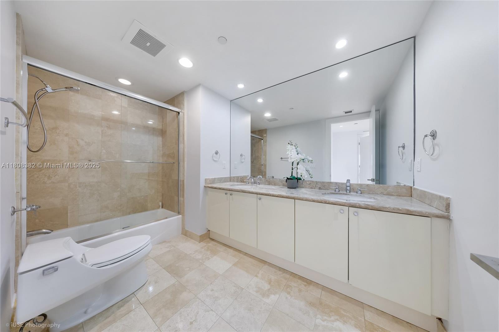 10225 Collins Avenue, Unit 604 Bal Harbour, FL 33154 - Photo 14 of 37 a bathroom with a granite countertop sink a toilet a mirror and shower