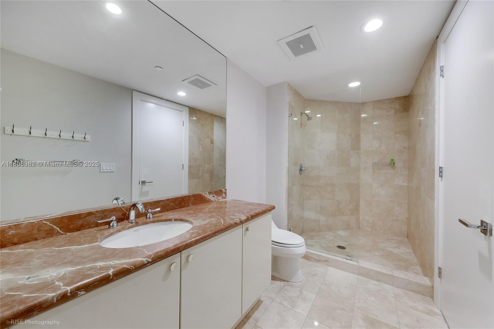 10225 Collins Avenue, Unit 604 Bal Harbour, FL 33154 - Photo 17 of 37 a bathroom with a granite countertop sink a toilet a mirror and shower