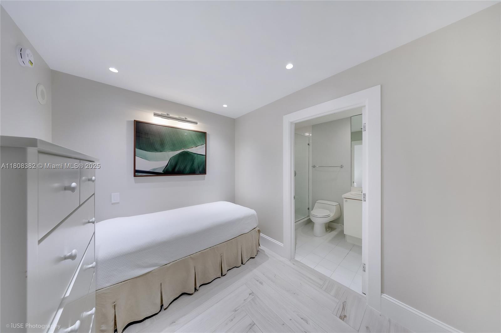 10225 Collins Avenue, Unit 604 Bal Harbour, FL 33154 - Photo 18 of 37 a spacious bedroom with a bed and a flat screen tv