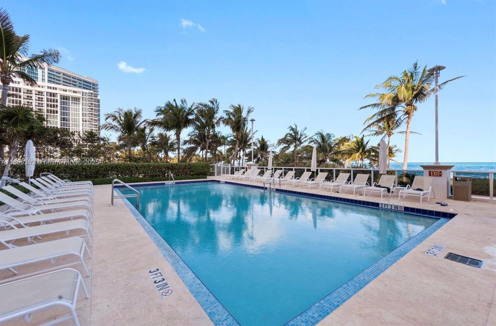 10225 Collins Avenue, Unit 604 Bal Harbour, FL 33154 - Photo 29 of 37 a view of a swimming pool with a lounge chairs