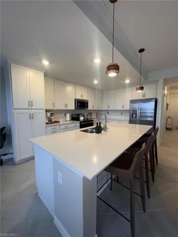 a kitchen with kitchen island a stove a table and chairs
