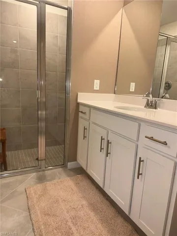 a bathroom with a double vanity sink mirror and shower
