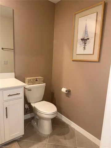a white toilet sitting next to a white sink and vanity