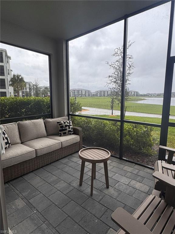 5583 Double Eagle Circle, Unit 4112 Ave Maria, FL 34142 - Photo 9 of 36 a living room with a floor to ceiling window and a table