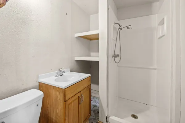 a bathroom with a sink a toilet and shower