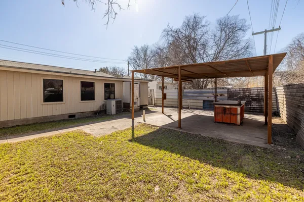 a backyard of a house with barbeque oven table and chairs