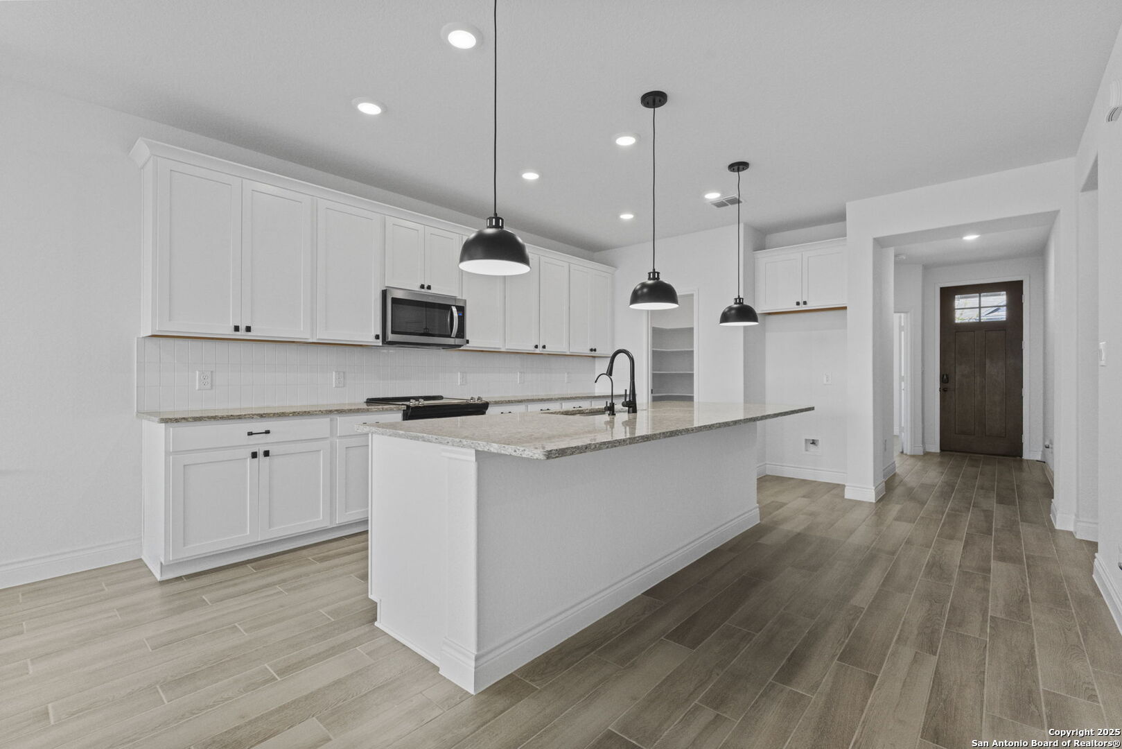 4014 Paddock Trail Seguin, TX 78155 - Photo 7 of 27 a large kitchen with stainless steel appliances sink a stove and wooden floor