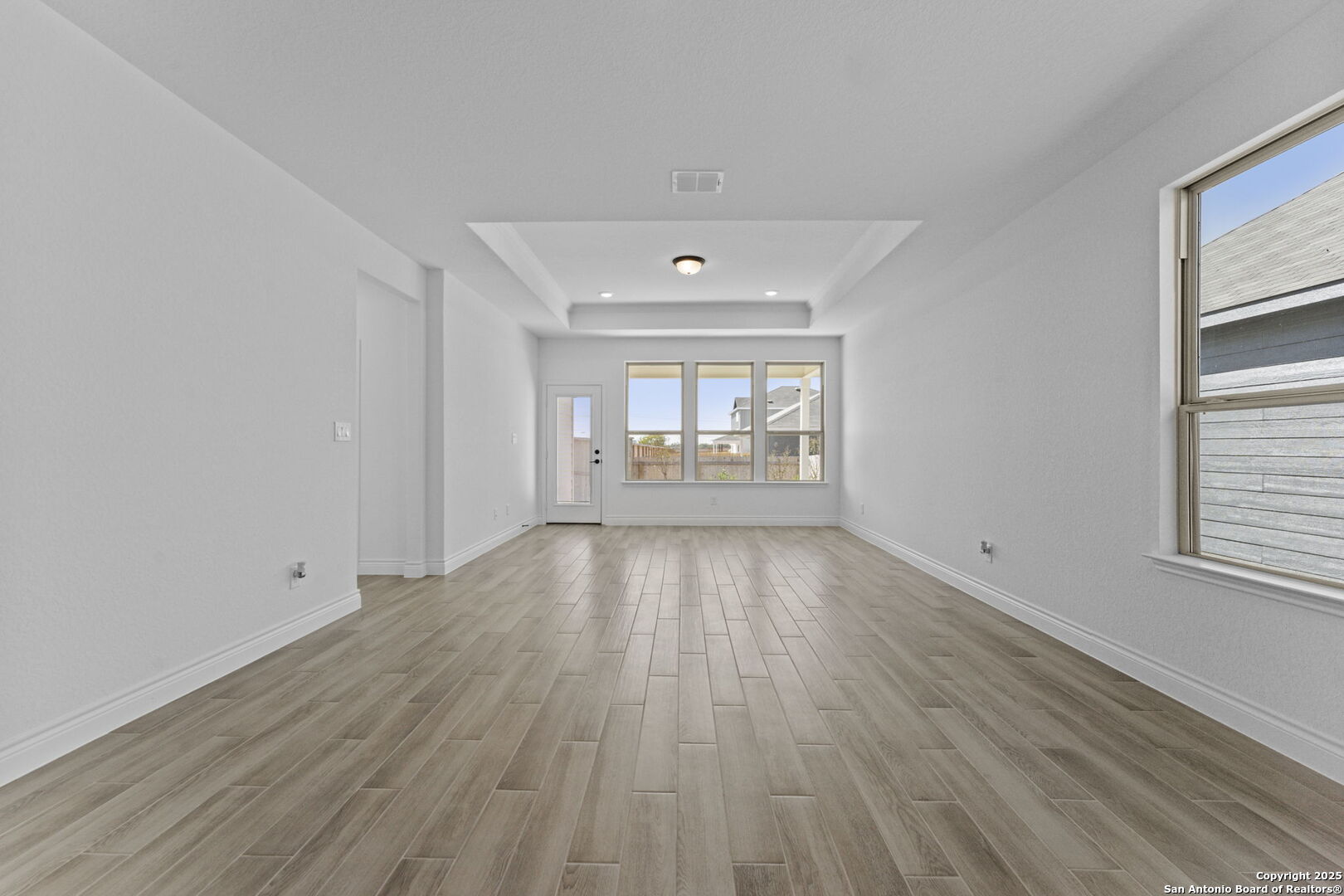 4014 Paddock Trail Seguin, TX 78155 - Photo 10 of 27 an empty room with wooden floor and windows