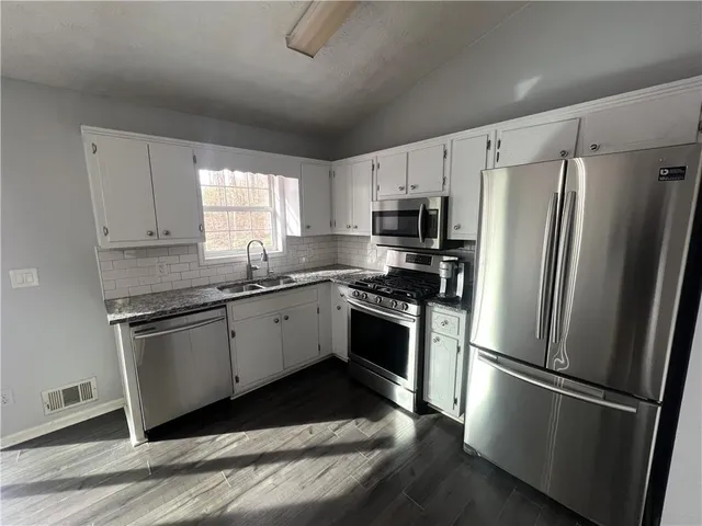 a kitchen with stainless steel appliances a refrigerator sink and microwave