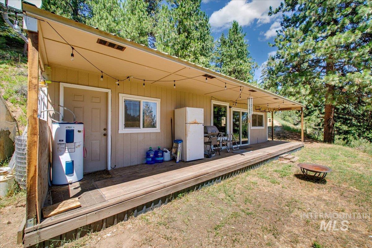 221 Tollgate Road Boise, ID 83716 - Photo 21 of 32 Wooden terrace featuring electric water heater, a fire pit, and a yard