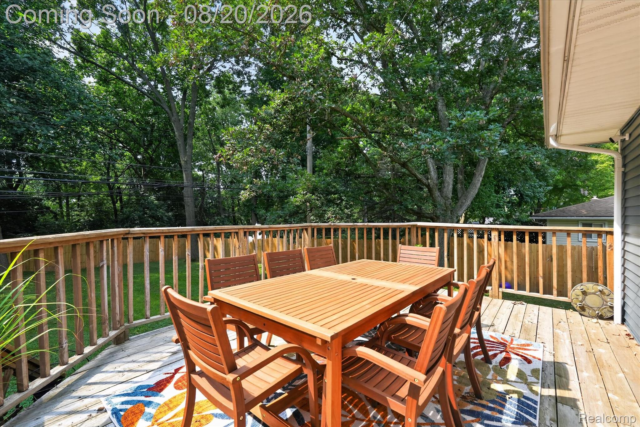 6235 Waldon Road Clarkston, MI 48346 - Photo 27 of 41 Expansive wood deck with a built-in wood railing, overlooking a fenced yard and mature trees