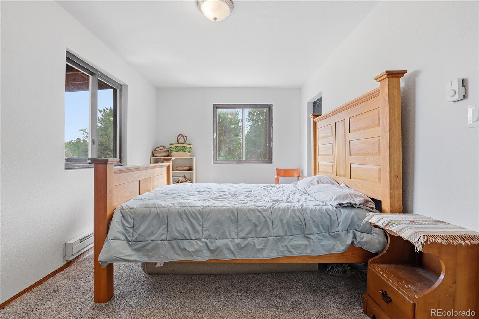 9225 Sandy Lane Conifer, CO 80433 - Photo 32 of 45 a bedroom with a bed and large windows