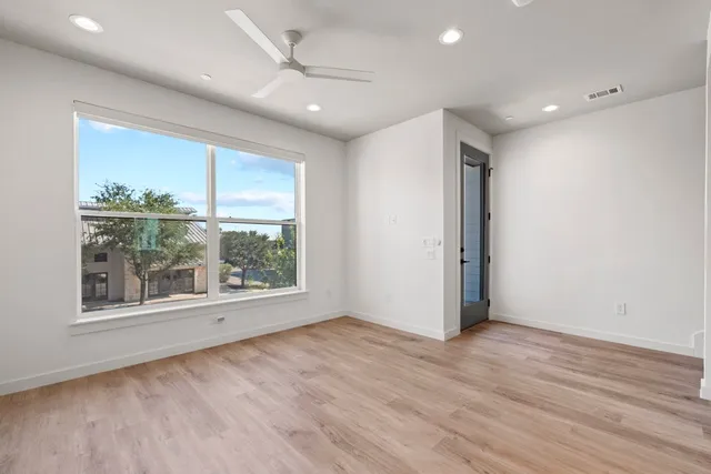 an empty room with wooden floor and a window