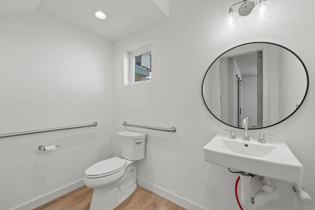 a bathroom with a sink a toilet and a mirror