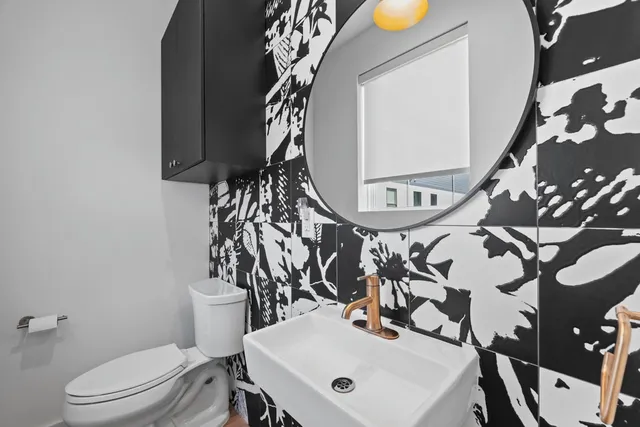 a bathroom with a sink a toilet and a mirror