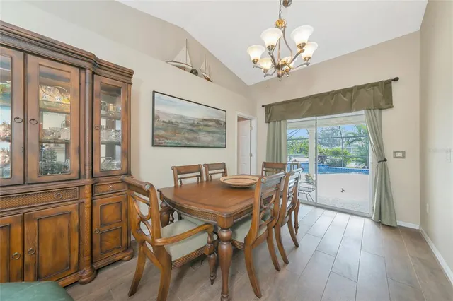 a dining room with furniture a chandelier and wooden floor