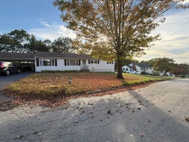a view of a house with a yard and sitting area