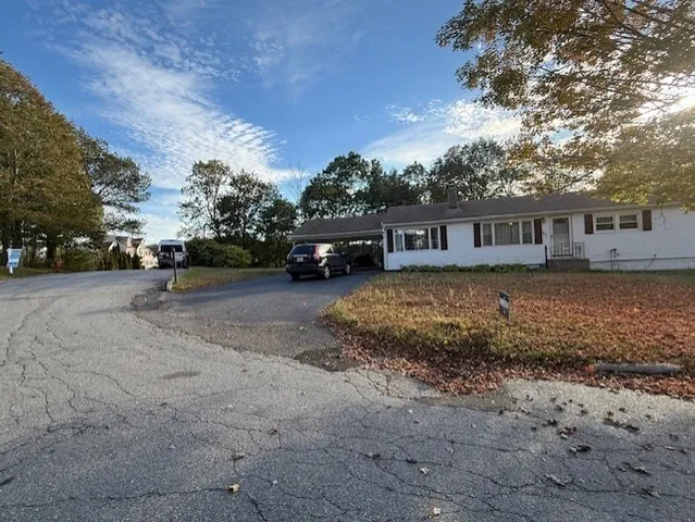 a view of a house with a yard and sitting area