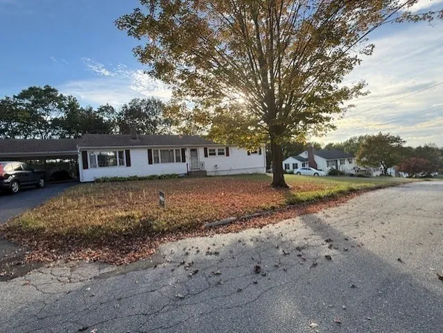 a view of house with car parked beside of road