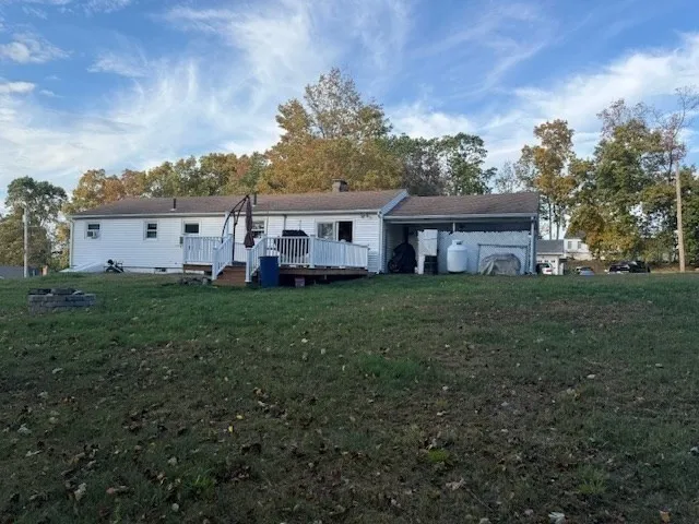 a view of a house with a big yard and large trees