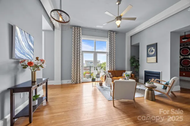 a living room with furniture a fireplace and a large window