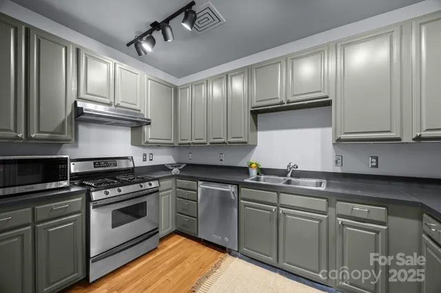 a kitchen with cabinets stainless steel appliances and a sink