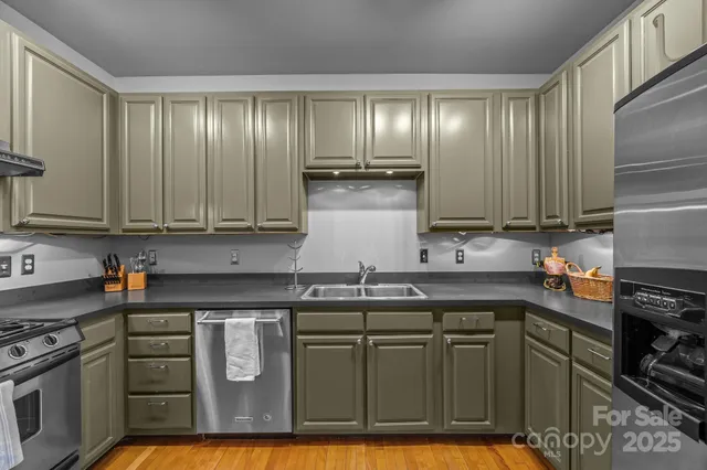 a kitchen with stainless steel appliances granite countertop a stove a sink and a microwave