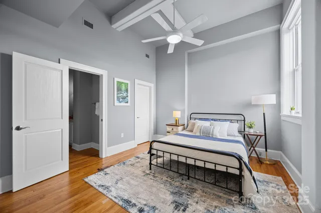 a bedroom with a bed and wooden floor