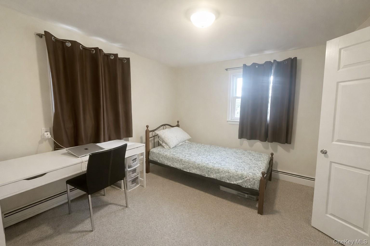 187 Horseblock Road Farmingville, NY 11738 - Photo 3 of 11 Bedroom featuring baseboard heating, light carpet, and an office area