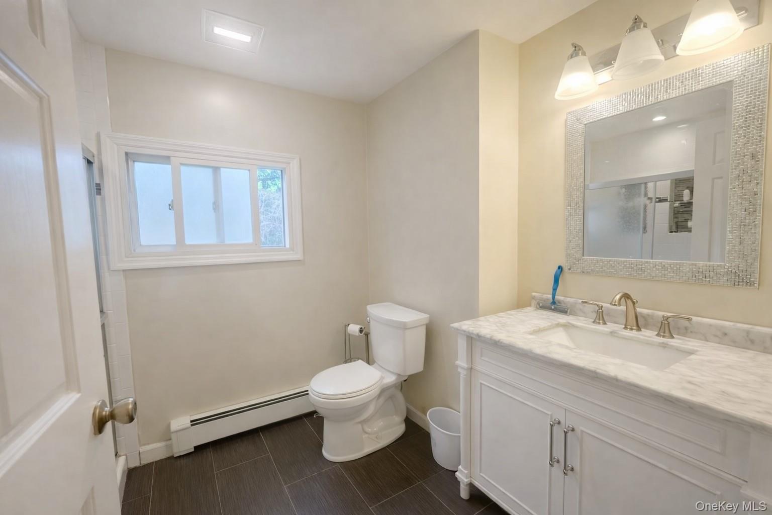 187 Horseblock Road Farmingville, NY 11738 - Photo 7 of 11 Full bath featuring a baseboard heating unit and vanity