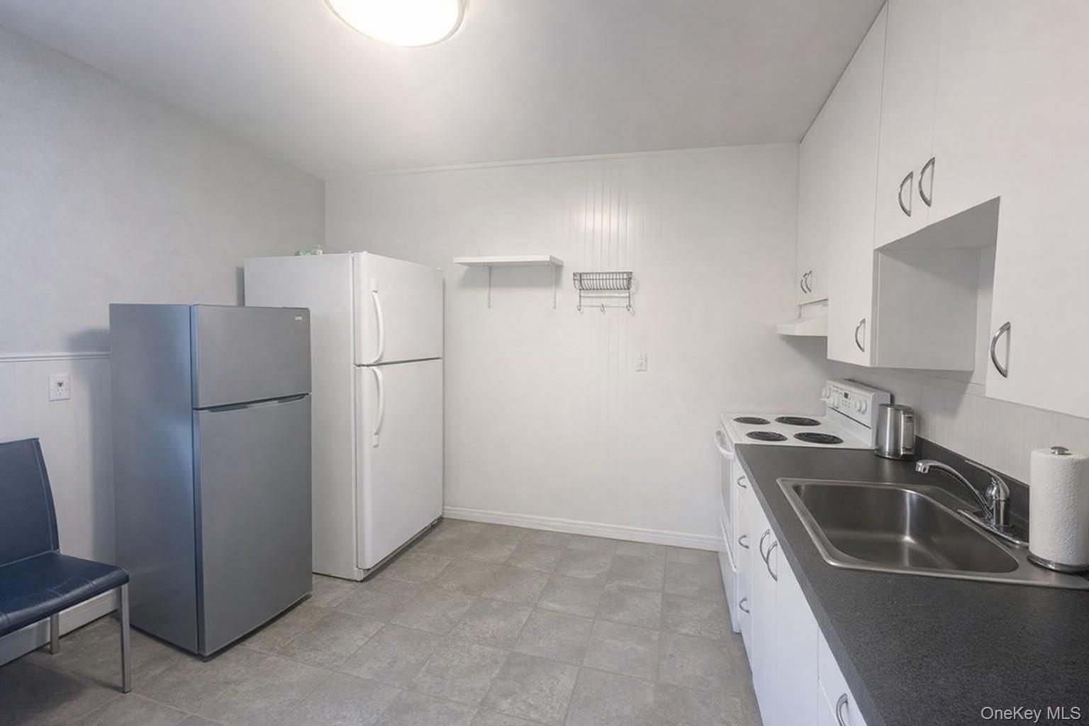 187 Horseblock Road Farmingville, NY 11738 - Photo 9 of 11 Kitchen with freestanding refrigerator, white cabinetry, white electric stove, and dark countertops