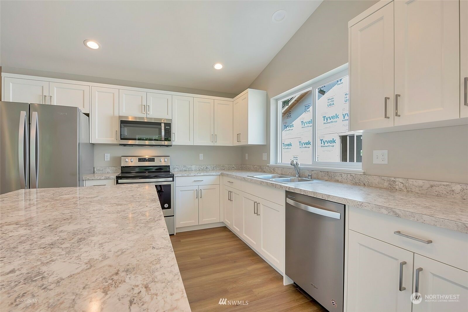 808 Nooksack Road Nooksack, WA 98276 - Photo 3 of 9 a kitchen with kitchen island granite countertop a sink stainless steel appliances and white cabinets