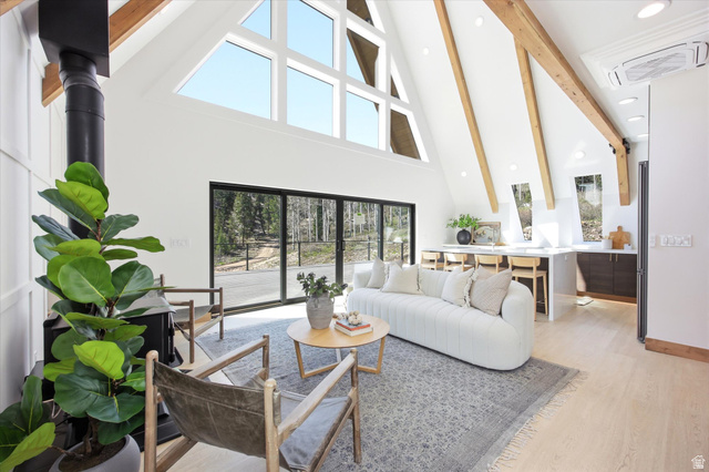 1833 Pine Loop Road Coalville, UT 84017 - Photo 2 of 26 Vaulted ceilings with exposed wood beams define this living area, featuring a prominent wood-burning stove and a wall of floor-to-ceiling windows