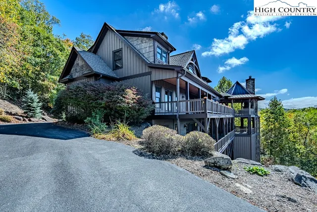 a view of a house with large windows and a small yard