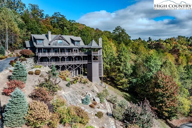 a view of a big house with a big yard and large trees
