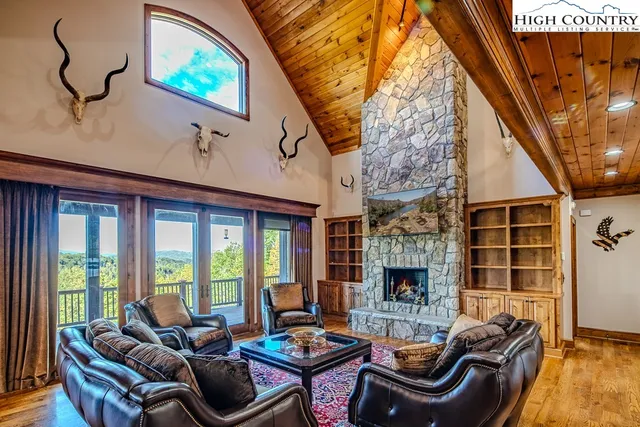 a living room with fireplace furniture and a floor to ceiling window