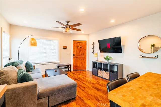 a living room with furniture kitchen view and a chandelier