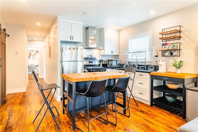 a kitchen with kitchen island granite countertop a sink a counter top space stainless steel appliances and cabinets
