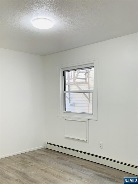 303 North 3rd Street, Unit 1 Harrison, NJ 07029 - Photo 5 of 11 an empty room with wooden floor and windows