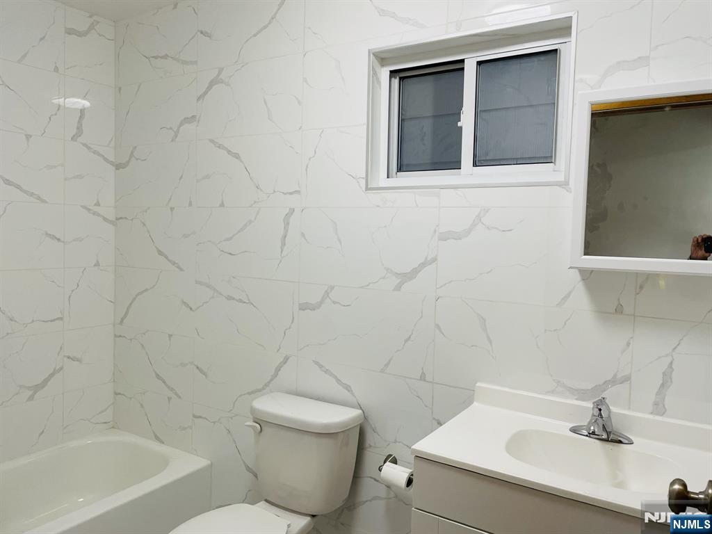 303 North 3rd Street, Unit 1 Harrison, NJ 07029 - Photo 6 of 11 a bathroom with a sink a toilet and shower