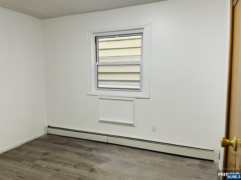 303 North 3rd Street, Unit 1 Harrison, NJ 07029 - Photo 8 of 11 an empty room with a wooden floor and a window